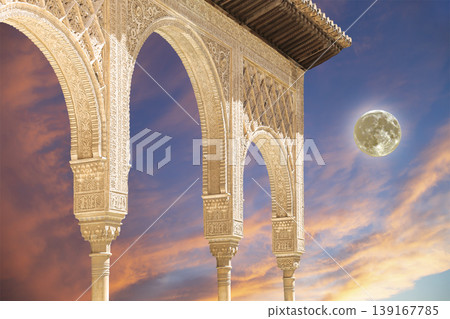 Arches in Islamic (Moorish) style (against the sunset with the super moon) in Alhambra, Granada, Spain Arches in Islamic (Moorish) style (against the sunset with the super moon) in Alhambra, Granada, Spain 139167785