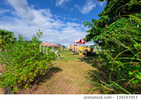 Ishigaki Island: A playground near Funakoshi Fishing Port, surrounded by blue skies and greenery. 139167953
