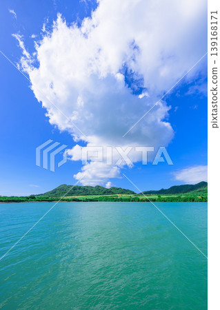 Ishigaki Island: The beautiful scenery of Funakoshi Fishing Port with its emerald sea and mountain range. 139168171