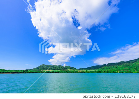 Ishigaki Island: The beautiful scenery of Funakoshi Fishing Port with its emerald sea and mountain range. 139168172