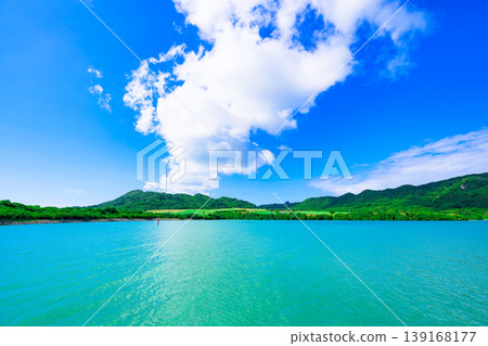 Ishigaki Island: The beautiful scenery of Funakoshi Fishing Port with its emerald sea and mountain range. 139168177