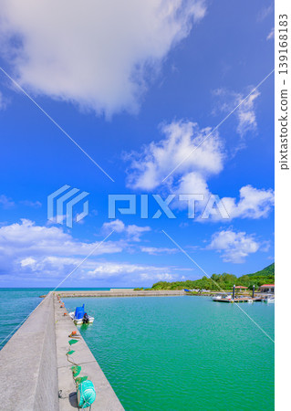 Ishigaki Island: The breakwater of Funakoshi Fishing Port, surrounded by blue skies and green mountains. Ishigaki Island: The breakwater of Funakoshi Fishing Port, surrounded by blue skies and green mountains. 139168183