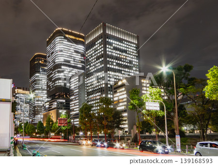 The lights of skyscrapers and the trails of car headlights illuminate the nighttime office district. The lights of skyscrapers and the trails of car headlights illuminate the nighttime office district. 139168593