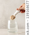 protein powder is poured into glass with water 139168677