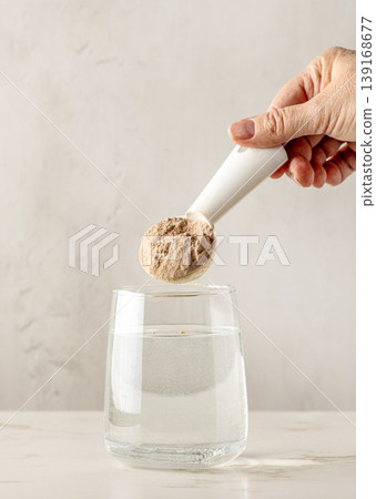 protein powder is poured into glass with water protein powder is poured into glass with water 139168677