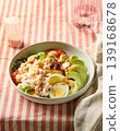 Healthy shrimp avocado salad bowl with egg and dressing on striped background 139168678