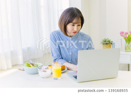 中年婦女邊工作邊吃早餐 中年婦女邊工作邊吃早餐 139168935