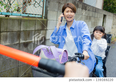 一名女子騎著腳踏車，手裡拿著一把傘。 139169220