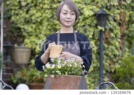 Senior women enjoying gardening in their yards Senior women enjoying gardening in their yards 139169676