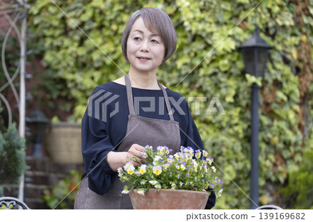 老年婦女們在自家院子裡享受園藝的樂趣 老年婦女們在自家院子裡享受園藝的樂趣 139169682