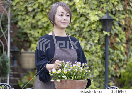 老年婦女們在自家院子裡享受園藝的樂趣 老年婦女們在自家院子裡享受園藝的樂趣 139169683