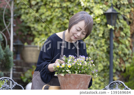 老年婦女們在自家院子裡享受園藝的樂趣 老年婦女們在自家院子裡享受園藝的樂趣 139169684