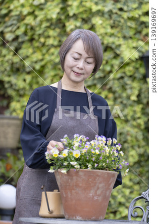 老年婦女們在自家院子裡享受園藝的樂趣 老年婦女們在自家院子裡享受園藝的樂趣 139169697