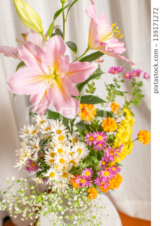 Image of a colorful flower arrangement: lilies, marigolds, chrysanthemums, baby's breath Image of a colorful flower arrangement: lilies, marigolds, chrysanthemums, baby's breath 139171272