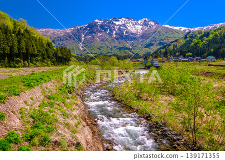 Mount Hakkai, with its remaining snow, stands out against the fresh greenery. Mount Hakkai, with its remaining snow, stands out against the fresh greenery. 139171355