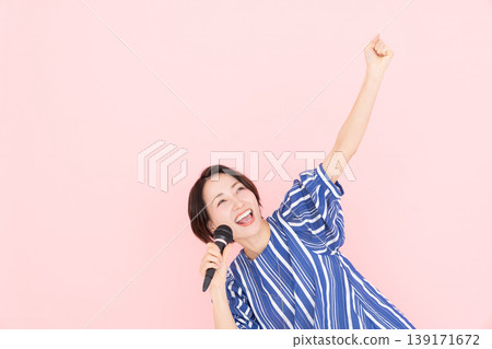 Middle-aged woman singing karaoke Middle-aged woman singing karaoke 139171672