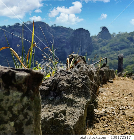 large rock at the top of the hill with a beautiful view in the background large rock at the top of the hill with a beautiful view in the background 139172517