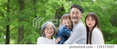 A springtime portrait of a three-generation family smiling and looking at the camera, capturing their happy family life in a park surrounded by fresh greenery. A springtime portrait of a three-generation family smiling and looking at the camera, capturing their happy family life in a park surrounded by fresh greenery. 139173007