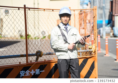 一名男性工地主管正拿著平板電腦查看施工現場的狀況。 一名男性工地主管正拿著平板電腦查看施工現場的狀況。 139173432