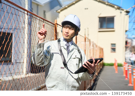 一名男性工地主管正拿著平板電腦查看施工現場的狀況。 一名男性工地主管正拿著平板電腦查看施工現場的狀況。 139173450