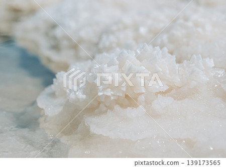 Intricate salt crystal formations sparkle near the clear water at Lake Baskunchak 139173565