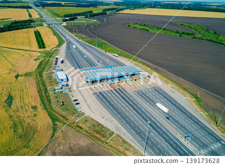 Aerial view of a multi-lane toll station on a wide highway with various vehicles during a sunny day Aerial view of a multi-lane toll station on a wide highway with various vehicles during a sunny day 139173628