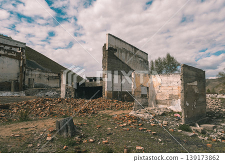 Abandoned building site with crumbling walls and scattered bricks in a rural area on a cloudy day Abandoned building site with crumbling walls and scattered bricks in a rural area on a cloudy day 139173862