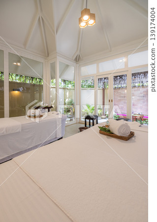 Elegant spa interior couple beds relaxing white decoration luxury hotel recreational wellness retreat serene atmosphere treatment room premium design massage therapy peaceful resort hospitality Elegant spa interior couple beds relaxing white decoration luxury hotel recreational wellness retreat serene atmosphere treatment room premium design massage therapy peaceful resort hospitality 139174004