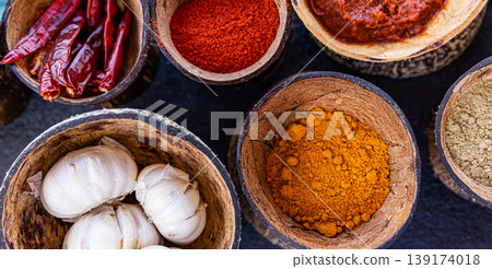 Fantastic top view indian spices colorful ingredients in wooden bowls aromatic masala turmeric chili curry powder coriander peppercorn culinary background organic healthy food composition 139174018