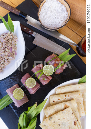 Gourmet kitchen cutting board with raw prepared fish and all ingredients knife fresh seafood culinary preparation healthy cooking background aromatic herbs spices lemon garlic rustic style Gourmet kitchen cutting board with raw prepared fish and all ingredients knife fresh seafood culinary preparation healthy cooking background aromatic herbs spices lemon garlic rustic style 139174021