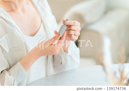 Hands of an Asian woman applying makeup (lipstick, lip gloss, lip gloss) Hands of an Asian woman applying makeup (lipstick, lip gloss, lip gloss) 139174736