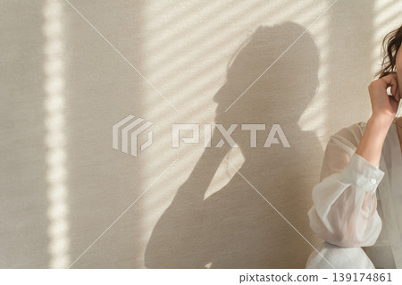 夕陽西下,窗邊站著一位女士(模特兒、時尚、光線、陰影) 夕陽西下,窗邊站著一位女士(模特兒、時尚、光線、陰影) 139174861