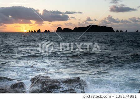 Sunrise and crashing waves off the coast of Nanatsu-iwa in the Hyuga Sea, Nichinan City, Miyazaki Prefecture. Sunrise and crashing waves off the coast of Nanatsu-iwa in the Hyuga Sea, Nichinan City, Miyazaki Prefecture. 139174981