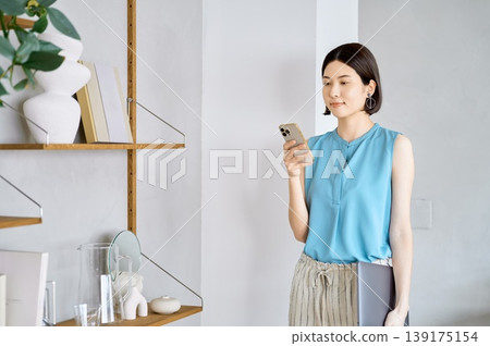 現代年輕亞洲女性在家中使用智慧型手機和筆記型電腦 現代年輕亞洲女性在家中使用智慧型手機和筆記型電腦 139175154