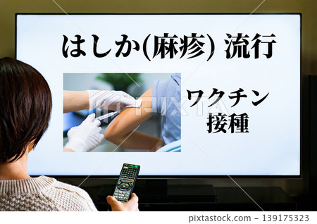 Watching TV news about measles and rubella outbreaks [Image of vaccination] 139175323