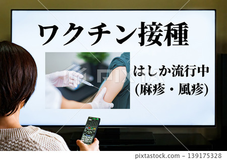 觀賞有關麻疹和德國麻疹疫情的電視新聞[接種疫苗的圖片] 139175328