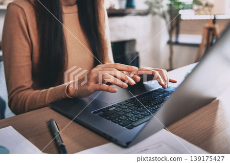 Woman types on laptop at home deskt Woman types on laptop at home deskt 139175427