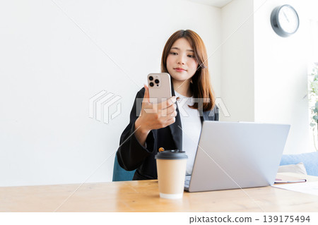 A woman watching a smartphone A woman watching a smartphone 139175494