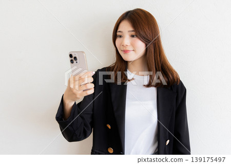 A woman watching a smartphone A woman watching a smartphone 139175497
