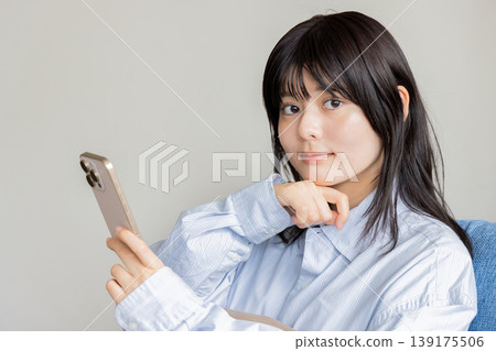 Woman operating a smartphone Woman operating a smartphone 139175506