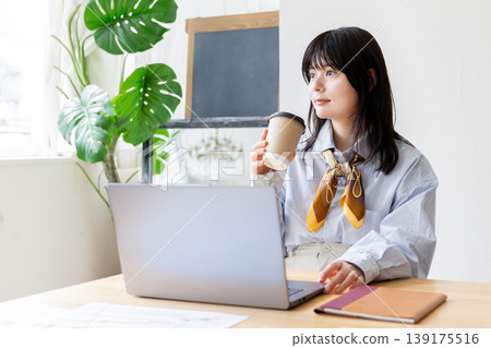 一位女士在共享辦公空間使用筆記型電腦。 139175516