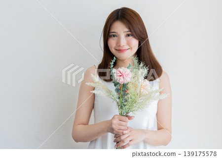 Natural portrait of a woman holding a bouquet of flowers - beauty and lifestyle image Natural portrait of a woman holding a bouquet of flowers - beauty and lifestyle image 139175578