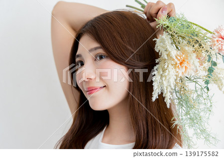 A beauty portrait of a woman holding a bouquet of flowers and smiling naturally. A beauty portrait of a woman holding a bouquet of flowers and smiling naturally. 139175582