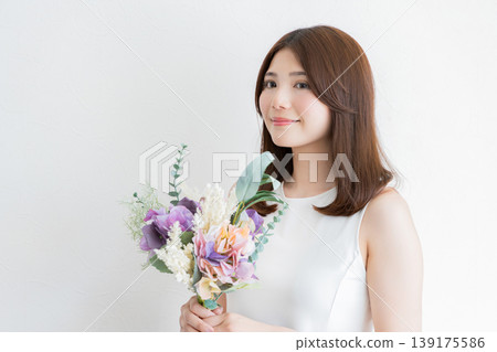 一位手捧鮮花的女士的自然側臉肖像 - 美麗與生活方式 一位手捧鮮花的女士的自然側臉肖像 - 美麗與生活方式 139175586