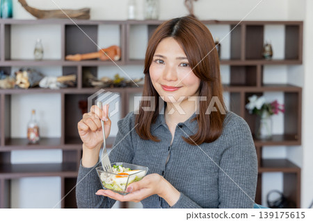 A health-conscious woman's lifestyle of enjoying salads at home A health-conscious woman's lifestyle of enjoying salads at home 139175615