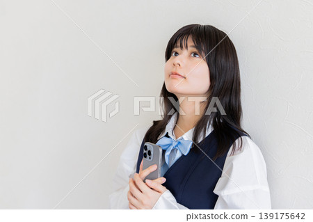 一位高中女生手持智慧型手機的肖像(白色背景,留白) 一位高中女生手持智慧型手機的肖像(白色背景,留白) 139175642