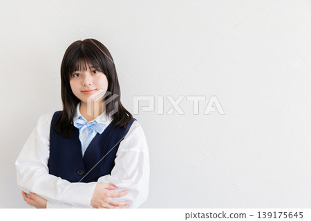 A portrait of a female student smiling with her arms crossed, exuding confidence and cleanliness (with space for copy). A portrait of a female student smiling with her arms crossed, exuding confidence and cleanliness (with space for copy). 139175645