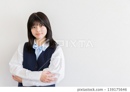 一位女學生面帶微笑,雙手交叉抱在胸前,散發著自信和整潔的氣質(留有文字空間)。 一位女學生面帶微笑,雙手交叉抱在胸前,散發著自信和整潔的氣質(留有文字空間)。 139175646