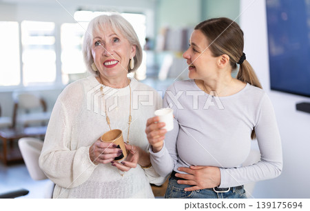 Elderly and adult women laughing and talking during coffee break Elderly and adult women laughing and talking during coffee break 139175694