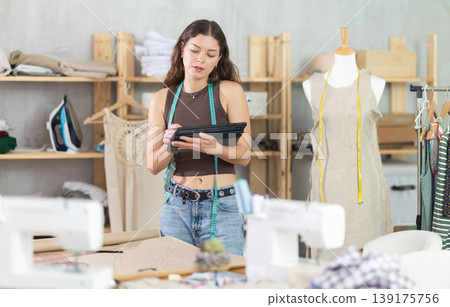 Tailor drawing fashion design on tablet in workshop Tailor drawing fashion design on tablet in workshop 139175756